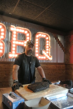 Pitmaster Nestor ready to cut into a perfect brisket at Hoodoo Brown BBQ in Ridgefield